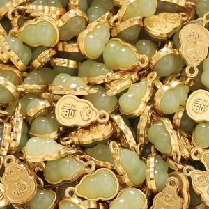 Macro view of gold-plated gourd pendant with faux jade inlay and 福 character engraving