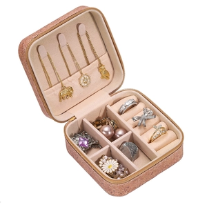 Vista interior del joyero marrón con ganchos para collares y ranuras para los anillos