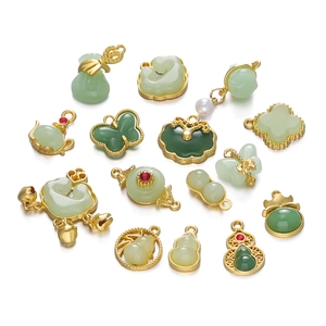 Detailed view of Chinese style gold-plated pendants with green faux jade in assorted shapes
