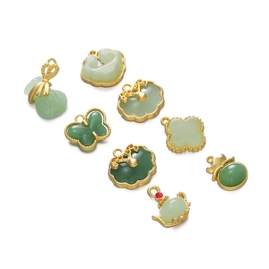 Detail view of various vintage green alloy pendants in auspicious lock and bag shapes