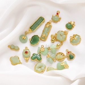 Detailed close-up of jade-like pendants with gold alloy frames in traditional Chinese motifs
