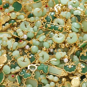 Detailed assortment of green faux-jade pendants with gold metal frames and pearl accents