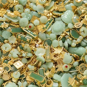 Close-up of bulk Chinese style DIY jewelry charms including jade-like pendants and gold alloy