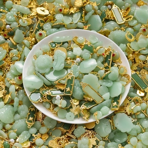 Macro shot of assorted Chinese style green jade pendants with gold alloy frames and carvings
