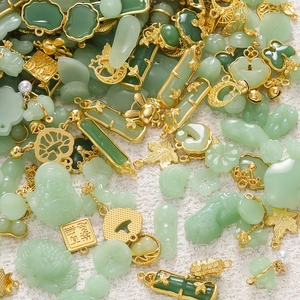 Macro detail of faux jade pendants in cloud and lotus shapes with gold metal frames
