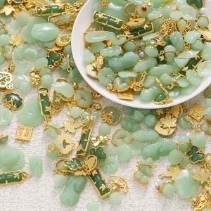 Macro detail of emerald green resin and gold alloy pendants with traditional Chinese patterns