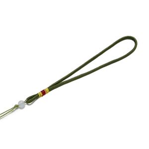 Détail du cordon tressé vert avec perle blanche et accents de fils de soie colorés