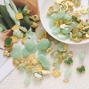 Macro shot of assorted gold alloy and jade charms featuring traditional Chinese motifs