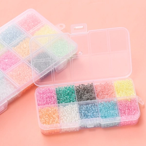 Detailed macro view of 10-grid organizers filled with 3mm colorful glass seed beads for DIY