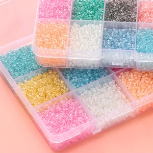 Close-up of organized 3mm glass seed beads in a multi-grid storage box for DIY jewelry