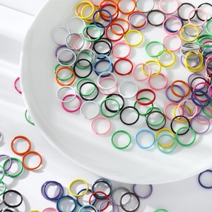 Vue détaillée d'anneaux ouverts laqués colorés éparpillés sur un fond blanc propre