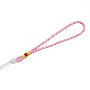 Vue détaillée du cordon tressé rose avec une perle blanche et un enroulement de soie colorée