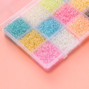 Detailed macro view of 3mm luminous glass seed beads organized in a plastic storage case