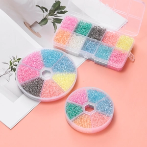 Flat lay of colorful 3mm glass seed bead kits in various plastic storage organizers