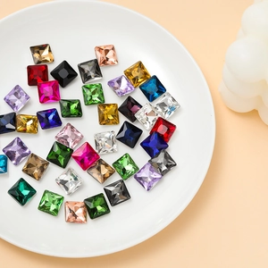 Macro shot of colorful princess cut square glass rhinestones in a white ceramic dish