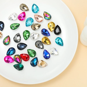 Macro shot of colorful teardrop-shaped crystal glass rhinestones with faceted surface