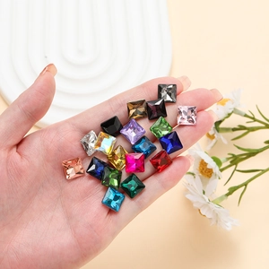 Macro view of colorful square pointed glass crystals held in hand for DIY craft work