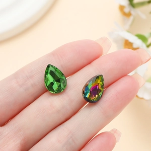 Macro shot of green and aurora pear-shaped crystal glass stones for sewing on dresses
