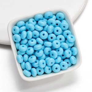 Close-up of light blue 8mm acrylic rondelle beads in a white bowl for DIY jewelry