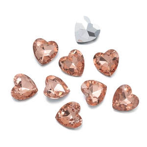 Vista macro di cristalli di vetro a forma di cuore oro rosa con taglio sfaccettato per fai da te