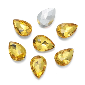 Macro shot of faceted teardrop glass rhinestones in amber yellow and metallic silver