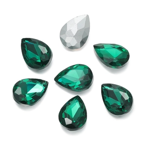 Macro shot of faceted teardrop glass crystals for DIY jewelry in emerald green and silver