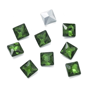 Macro detail of faceted green square crystal rhinestones with silver pointed back