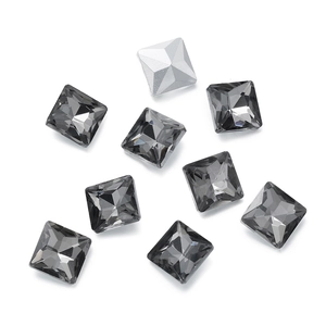 Detailed view of faceted dark grey glass square crystals with silver foil backing