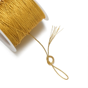 Primer plano de carrete de cordón de poliéster dorado con textura trenzada de varios hilos