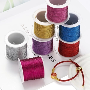 Primer plano de hilos metálicos de poliéster para DIY con pulsera roja de la suerte