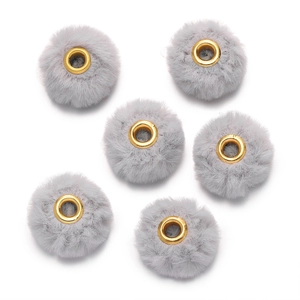 Macro detail of six grey plush faux rabbit fur beads with golden metal eyelets for DIY crafts