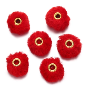 Macro shot of six red faux rabbit fur beads with golden metal grommets for DIY jewelry