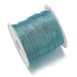 Detalle macro de hilo de poliéster azul metálico en carrete para creación de joyas DIY