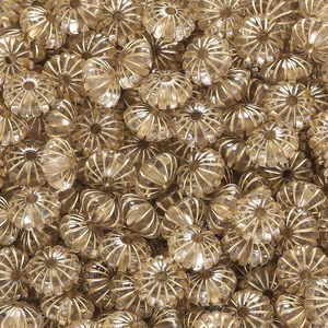 Makrodetail von kürbisförmigen Acrylperlen mit Goldfolie für DIY-Schmuckherstellung