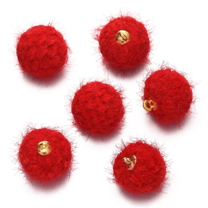Vue détaillée de six pompons en fausse fourrure rouge avec anneaux mousquetons dorés