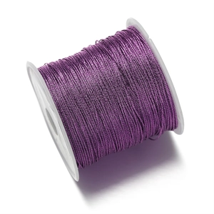 Primer plano de cordón trenzado de poliéster morado en carrete para hacer joyas