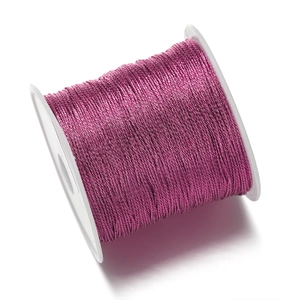 Primer plano de cordón de joyería de poliéster rosa oscuro en un carrete blanco