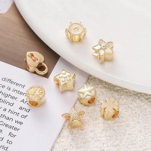 Gros plan de perles d'espacement CCB dorées en formes de cœur, d'étoile et de fleur