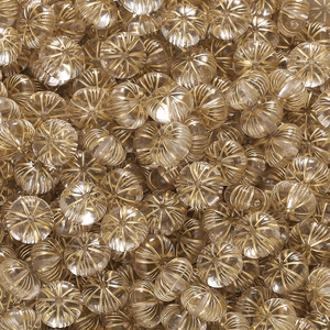 Makroaufnahme von kürbisförmigen Acrylperlen mit Goldfolienrillen für DIY-Schmuck