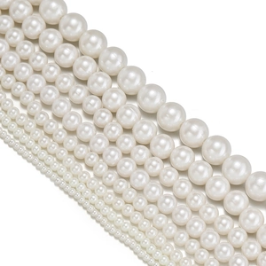 Detailed view of various sizes of round white ABS imitation pearls with high gloss finish