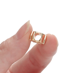 Vue macro d'une perle d'espacement dorée avec texture verticale pour bijoux DIY