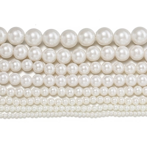 Detailed macro view of white ABS faux pearl beads in multiple sizes ranging from 2mm to 12mm