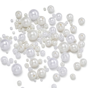 Detailed view of various sizes of glossy cream white ABS faux pearls with pre-drilled holes