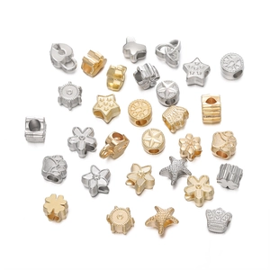 Vue macro de perles d'espacement CCB dorées et argentées en formes d'étoile et de cœur