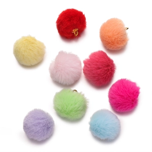 Detailed view of nine colorful faux fur pom-pom charms with golden metal loops for DIY jewelry