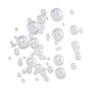 Detail view of various sizes of white ABS imitation pearls with holes for DIY jewelry making