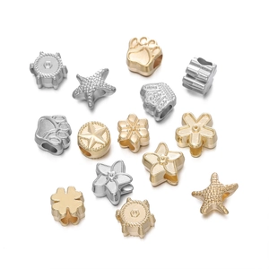 Détail de perles de bijoux DIY dorées et argentées en formes d'étoiles et de fleurs variées