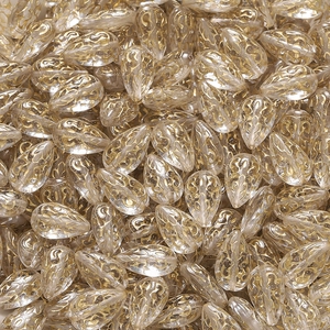 Makroaufnahme von Tropfen-Acrylperlen mit goldenem Filigranmuster für DIY-Schmuck
