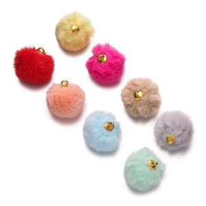 Detailed view of colorful plush balls with gold metal loops for DIY jewelry making