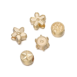 Vue détaillée de perles d'espacement dorées avec motifs d'arbre de vie et d'étoile pour DIY